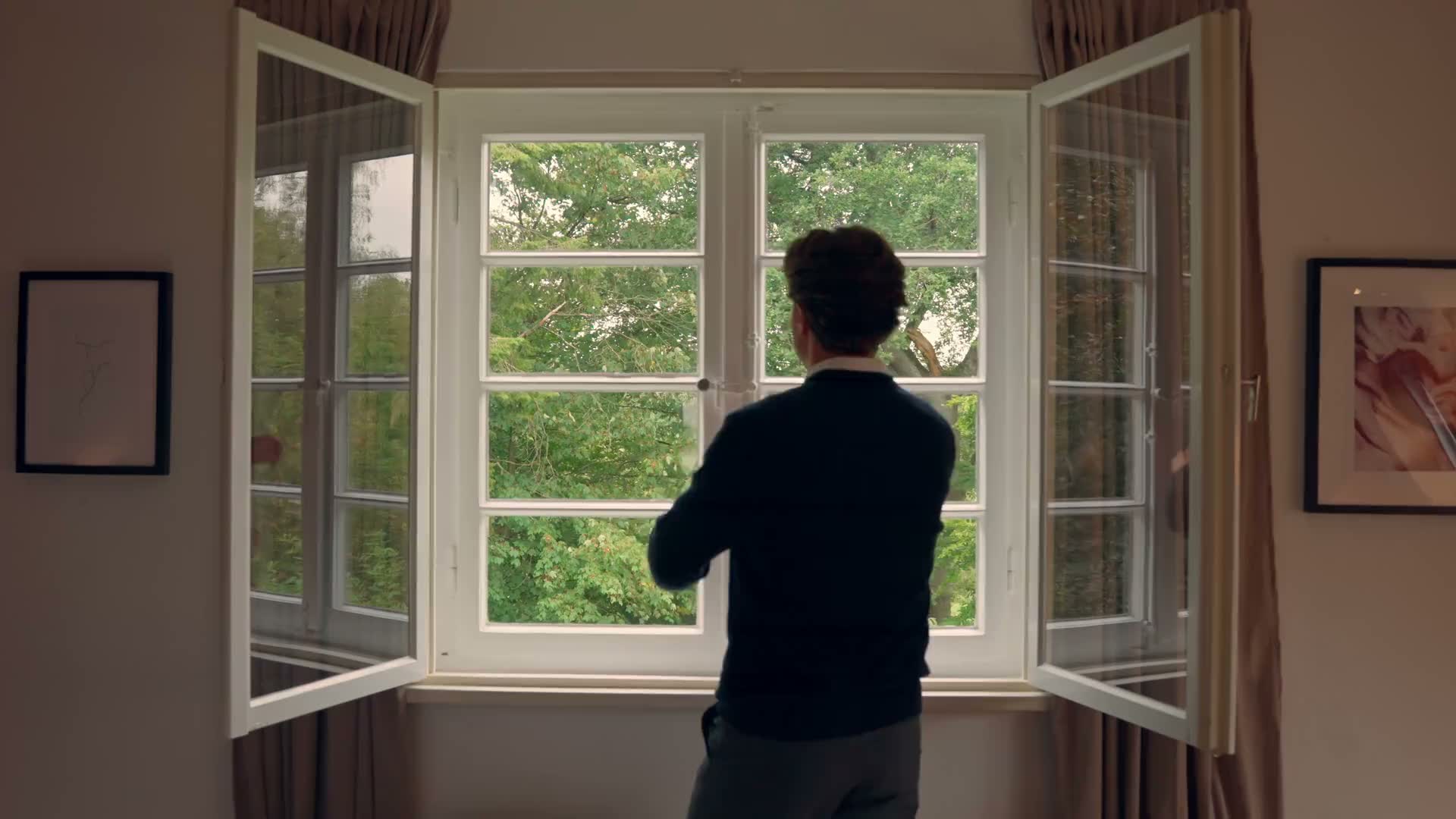 Person standing at an open window