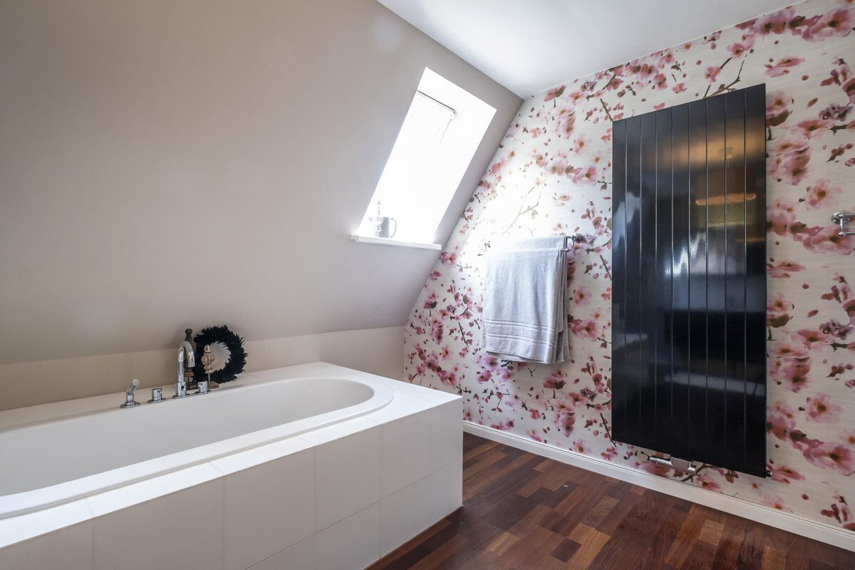 Bathroom with wooden floorboards and stylish wallpaper