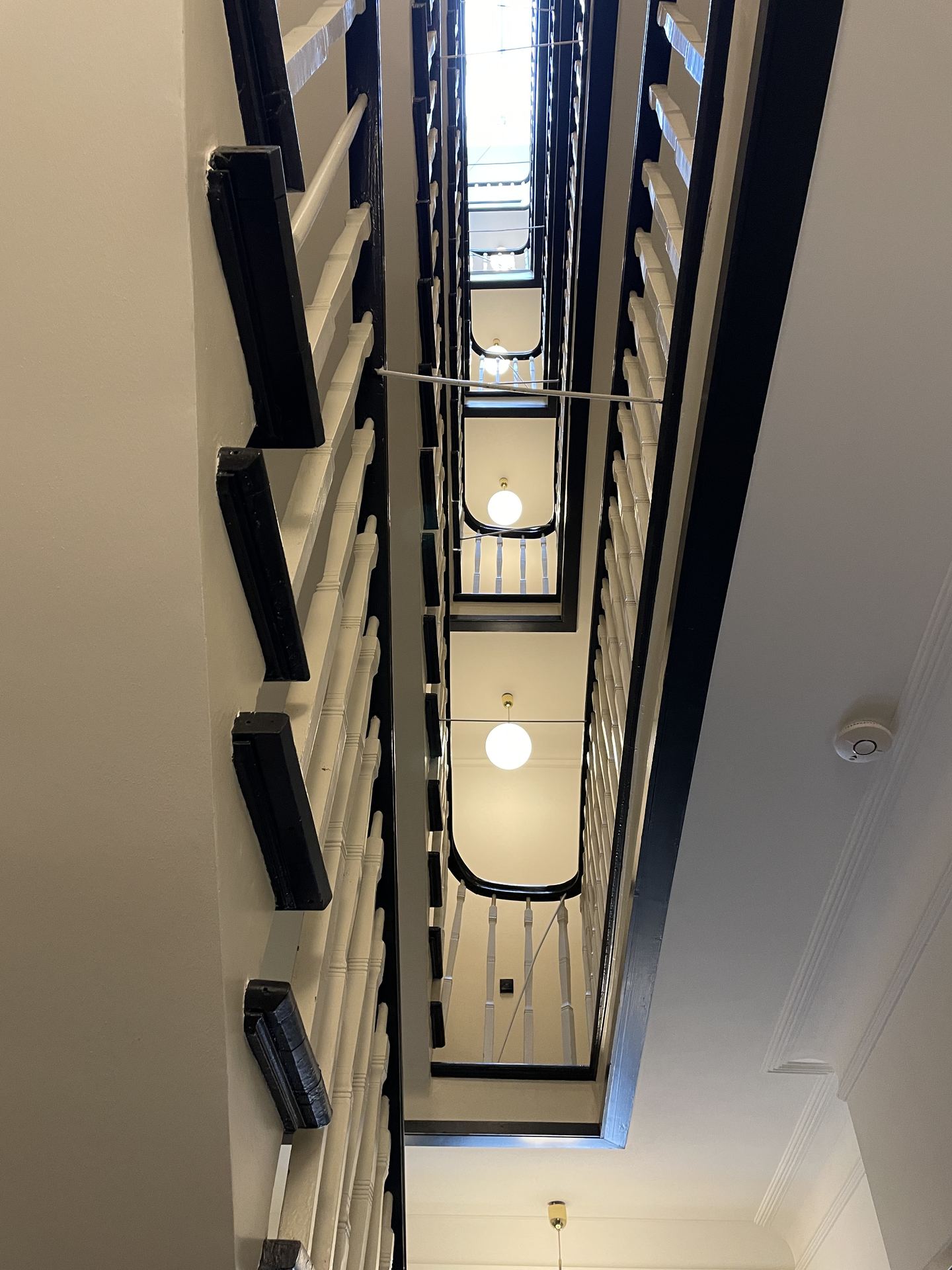 Treppenhaus mit Geländer und Deckenleuchten