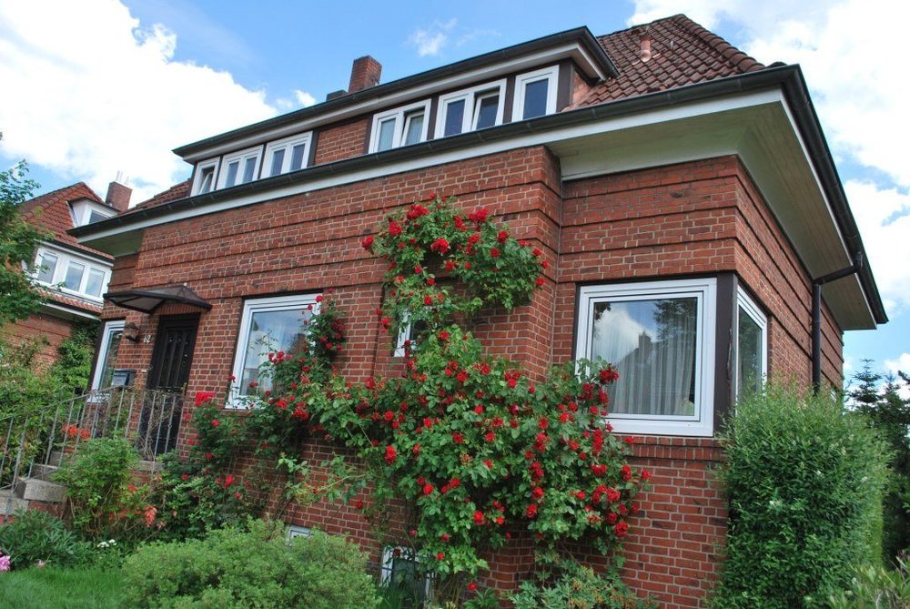 Brick house with a garden and red flowers