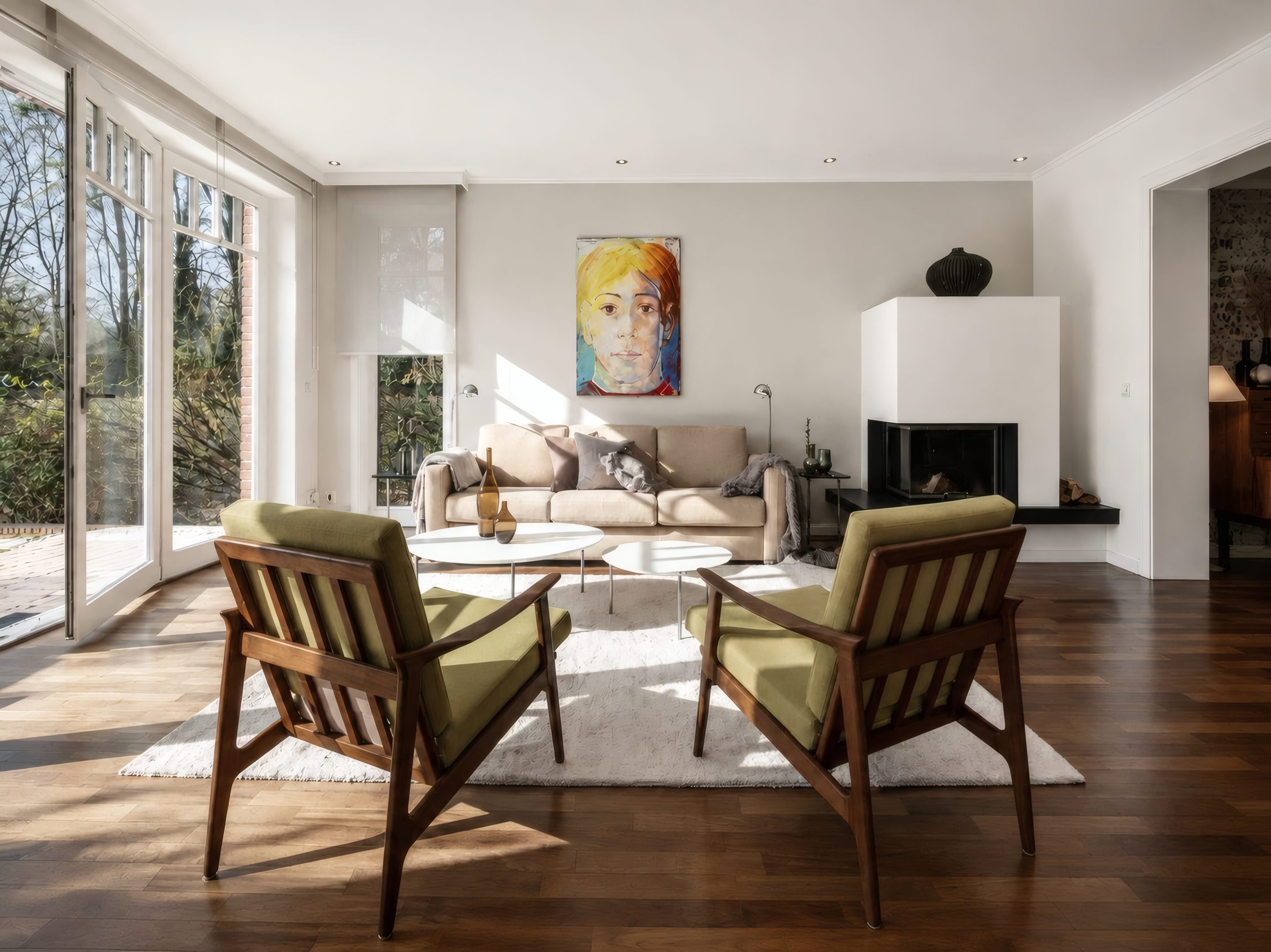 Sunlit living room with armchairs and a view into the garden